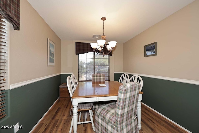 dining area featuring an inviting chandelier and dark hardwood / wood-style floors