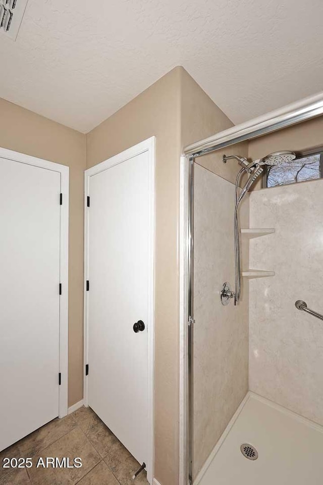 bathroom featuring a shower and a textured ceiling