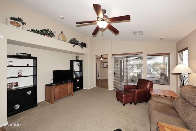 carpeted living room with ceiling fan and vaulted ceiling