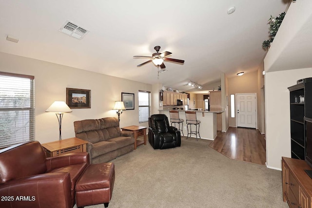 living room featuring light carpet and ceiling fan