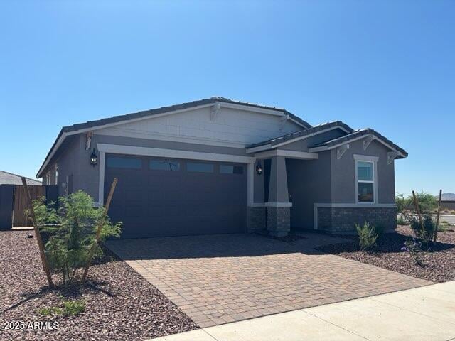 5573 S 246th Ave, Buckeye, AZ 85326 - craftsman-style house with decorative driveway, a garage, stone siding, and stucco siding