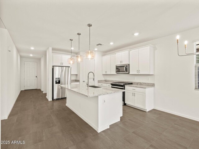 5573 S 246th Ave, Buckeye, AZ 85326 - kitchen with stainless steel appliances, white cabinets, an island with sink, and recessed lighting