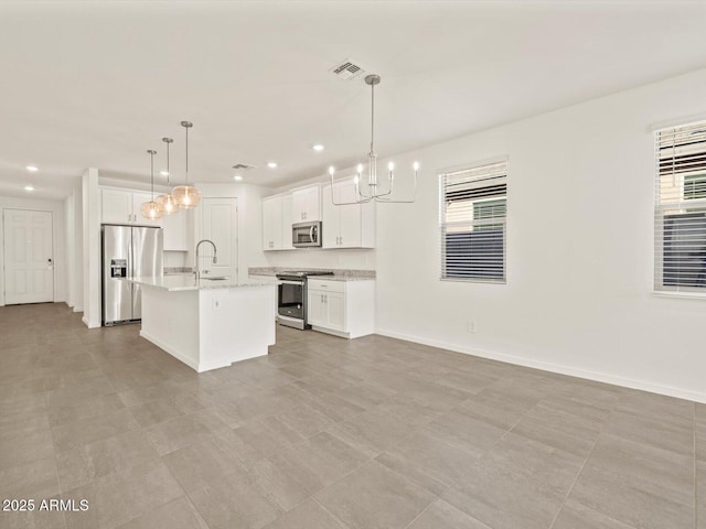 5573 S 246th Ave, Buckeye, AZ 85326 - kitchen with stainless steel appliances, a chandelier, healthy amount of natural light, white cabinetry, and recessed lighting