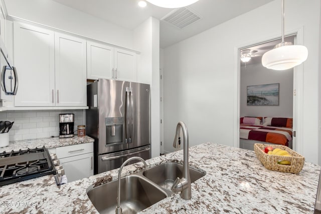 21716 E Waverly Dr, Queen Creek, AZ 85142 - kitchen featuring tasteful backsplash, stainless steel appliances, light stone countertops, and white cabinets
