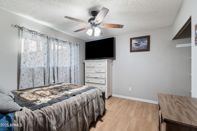 bedroom featuring ceiling fan, a textured ceiling, and light hardwood / wood-style flooring