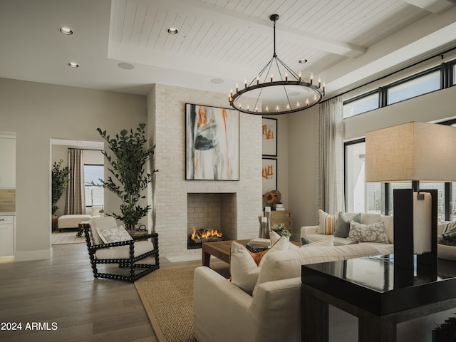 living room featuring a notable chandelier, a fireplace, a wealth of natural light, and wood-type flooring