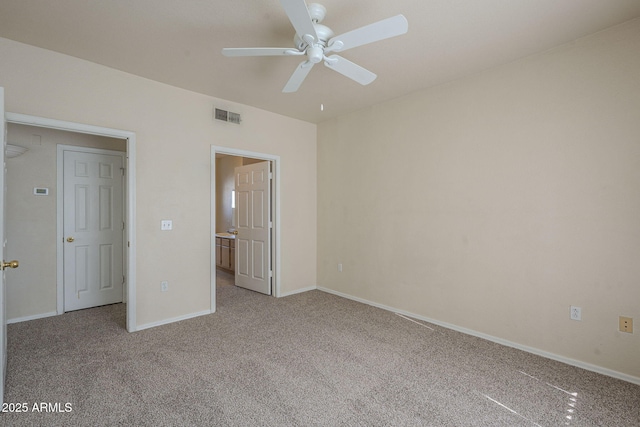 unfurnished bedroom featuring ceiling fan, light carpet, and ensuite bath