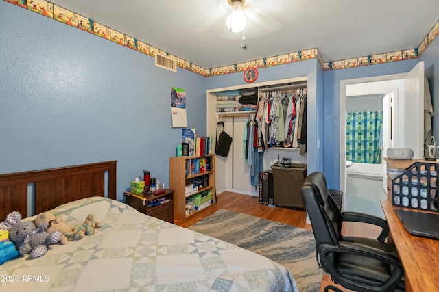 bedroom with light hardwood / wood-style flooring, a closet, and ceiling fan