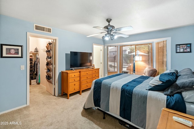 bedroom featuring ceiling fan, a spacious closet, light carpet, and a closet