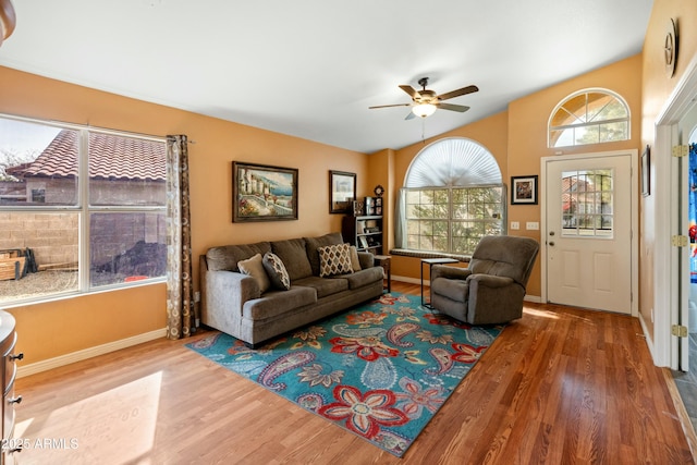 living room featuring ceiling fan, wood-type flooring, and vaulted ceiling