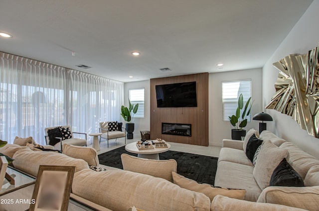 living room featuring a large fireplace and a wealth of natural light