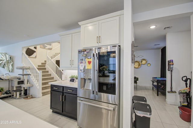 kitchen featuring light tile patterned floors, white cabinets, and stainless steel fridge with ice dispenser