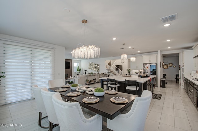 tiled dining area featuring sink and a notable chandelier