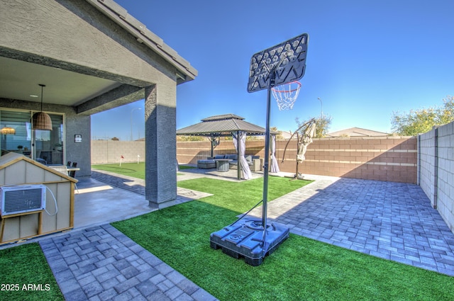 view of yard featuring a patio, a storage unit, a wall mounted AC, an outdoor hangout area, and a gazebo