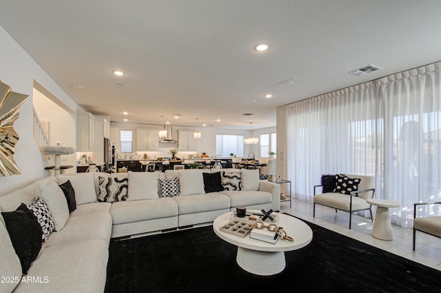 tiled living room featuring a notable chandelier