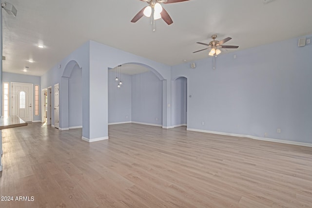 empty room with ceiling fan and light hardwood / wood-style flooring