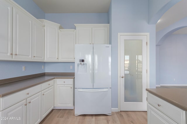 kitchen featuring white cabinetry, light hardwood / wood-style flooring, and white fridge with ice dispenser