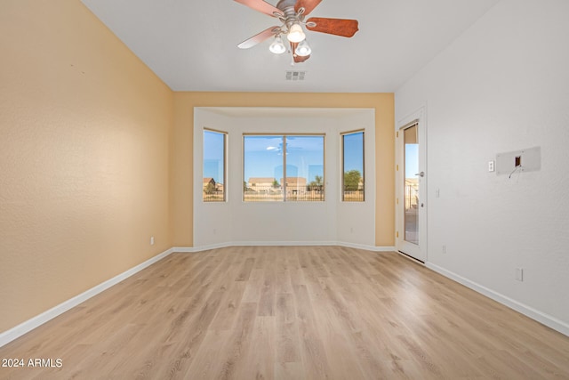 spare room with ceiling fan and light wood-type flooring