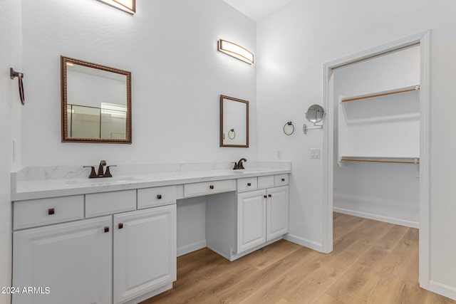 bathroom featuring hardwood / wood-style flooring, dual sinks, and vanity with extensive cabinet space