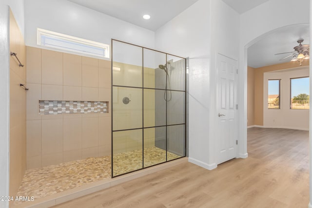 bathroom featuring a shower with door, hardwood / wood-style flooring, and ceiling fan