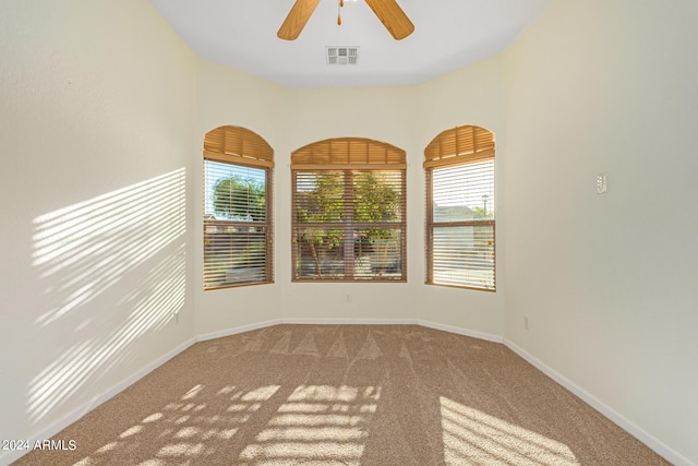 carpeted spare room with ceiling fan