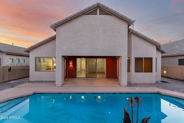 pool at dusk with a patio