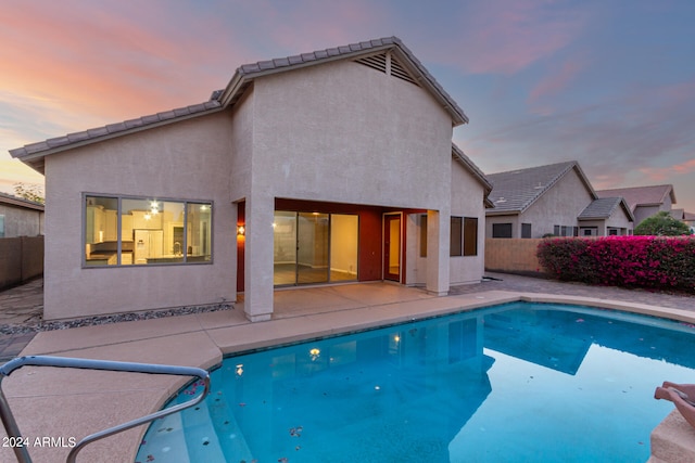 pool at dusk with a patio