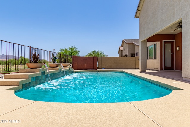 view of swimming pool with ceiling fan, a patio area, and pool water feature