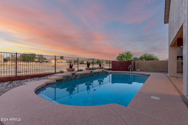 pool at dusk featuring a patio