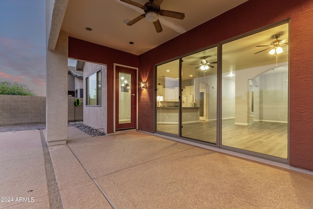 patio terrace at dusk featuring ceiling fan