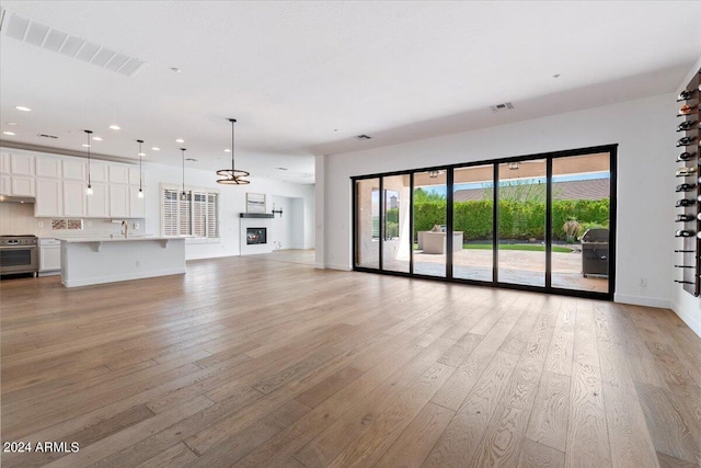 41817 N Bridlewood Way, Phoenix, AZ 85086 - unfurnished living room featuring recessed lighting, light wood-type flooring, baseboards, a sink, and visible vents