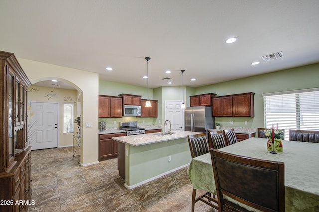 6554 W Rushmore Way, Florence, AZ 85132 - kitchen with stainless steel appliances, decorative light fixtures, an island with sink, recessed lighting, and arched walkways