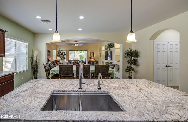 6554 W Rushmore Way, Florence, AZ 85132 - kitchen featuring ceiling fan, light stone counters, open floor plan, decorative light fixtures, and recessed lighting