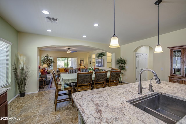 6554 W Rushmore Way, Florence, AZ 85132 - kitchen with ceiling fan, light stone countertops, hanging light fixtures, recessed lighting, and open floor plan