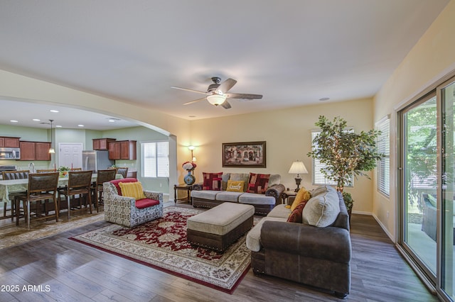 6554 W Rushmore Way, Florence, AZ 85132 - living area with arched walkways, dark wood-type flooring, and ceiling fan