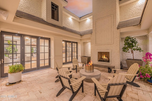 view of patio featuring an outdoor brick fireplace and french doors