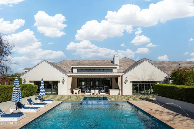 rear view of house featuring pool water feature and a patio area