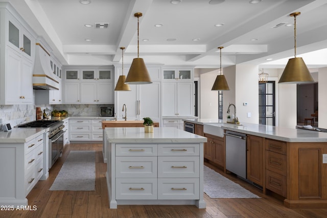 kitchen featuring decorative light fixtures, white cabinetry, a large island, light stone counters, and stainless steel appliances