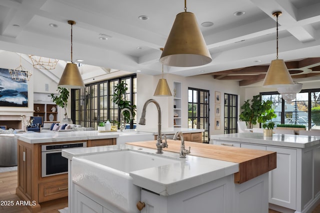 kitchen with white cabinetry, stainless steel oven, a large island, and pendant lighting