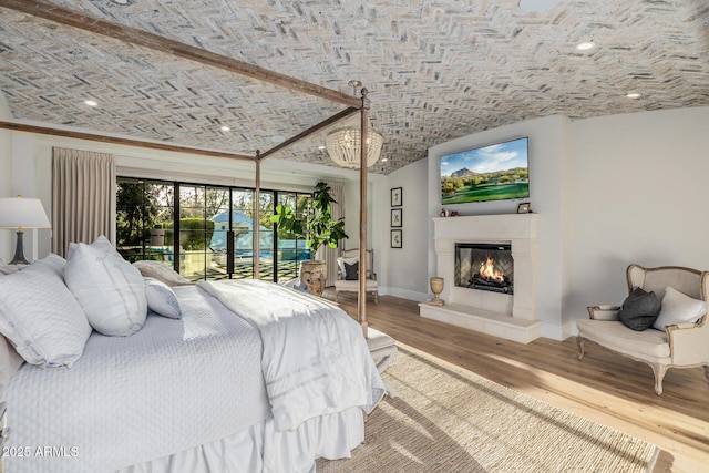 bedroom with brick ceiling, wood-type flooring, and access to exterior