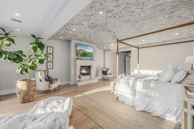 bedroom featuring brick ceiling and light hardwood / wood-style floors