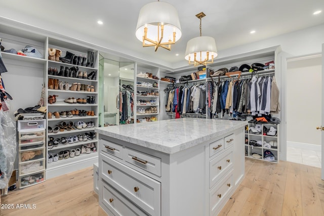 walk in closet with light hardwood / wood-style floors