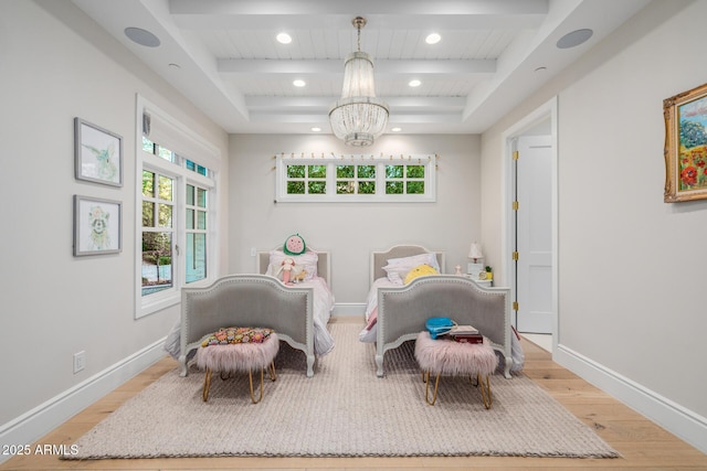 living area with an inviting chandelier, beamed ceiling, and light wood-type flooring