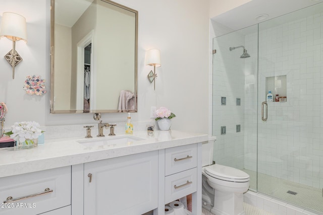 bathroom with walk in shower, vanity, and toilet