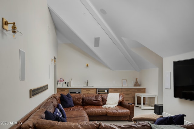 carpeted living room featuring vaulted ceiling, beverage cooler, and indoor wet bar