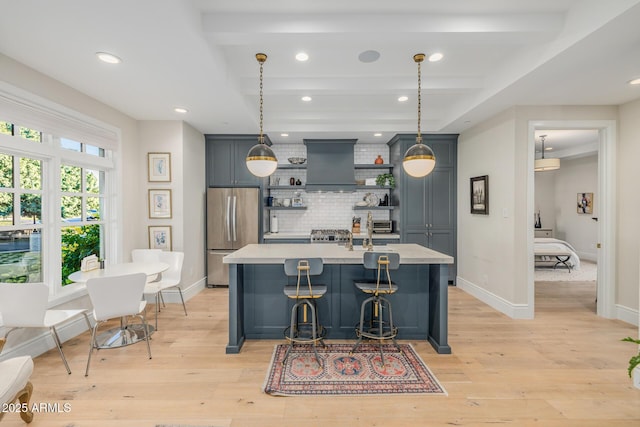 kitchen with premium range hood, stainless steel fridge, decorative light fixtures, and light wood-type flooring