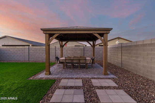 patio terrace at dusk featuring a gazebo, an outdoor living space, and a lawn