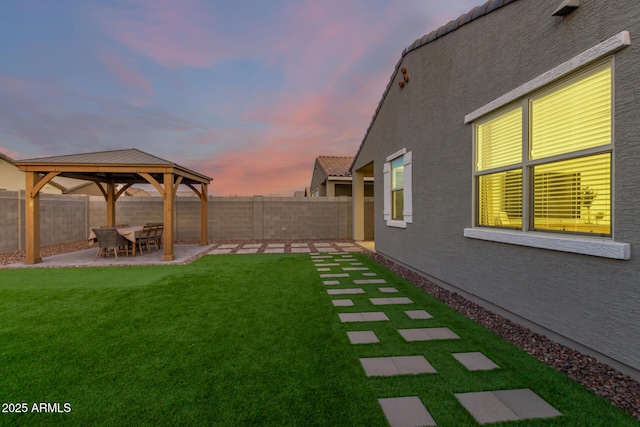 yard at dusk with a gazebo and a patio area