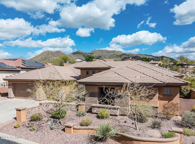 view of front of home with a garage and a mountain view