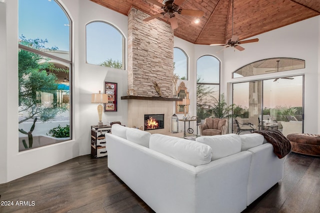 living room with wood ceiling, a large fireplace, high vaulted ceiling, and a healthy amount of sunlight